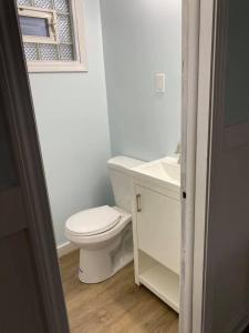 a white bathroom with a toilet and a sink at The Palms Motel in Geneva-on-the-Lake