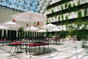 een groep tafels en stoelen met parasols in een gebouw bij Cantalagua Inn in Atlacomulco de Fabela