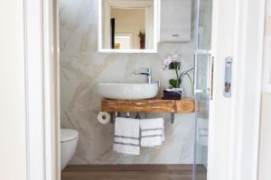La salle de bains est pourvue d'un lavabo et d'un miroir. dans l'établissement Elena Casa Turistica, à Padoue