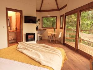 a bedroom with a bed and a living room with a fireplace at Secret do Gerês in Vieira do Minho