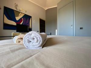a white towel laying on top of a bed in a hotel room at Alex Room Airport in Elmas