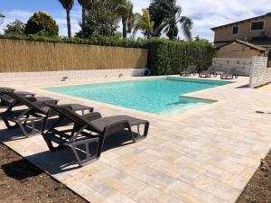 a swimming pool with chaise lounges and chairs around it at Casa Zagara in Avola