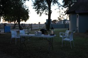 a table and chairs in a yard with a grill at Brakkies the Country dog Escape in Moorreesburg
