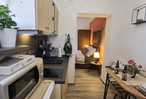 a kitchen with a stove top oven next to a table at Studio Apartman Lipik in Lipik