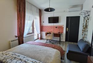 a bedroom with a bed and a desk and a chair at Studio Apartman Lipik in Lipik