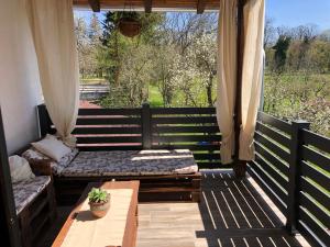 a porch with a bench and a table and a window at Studio Apartman Lipik in Lipik