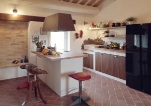 una cocina con encimera y algunos taburetes en ella en SelvaGiurata farmhouse villa, en San Benedetto del Tronto