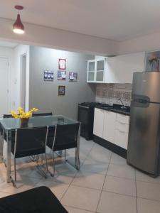 een keuken met een tafel en een roestvrijstalen koelkast bij Apartamento Bem Localizado Centro de SP in Sao Paulo