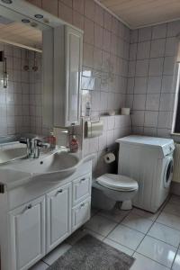 カッセルにあるプリヴァートツィマー ケーニッヒのバスルーム(洗面台、トイレ、鏡付)