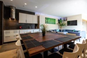 a kitchen and dining room with a large wooden table at Vlaamse Ardennen Vakantiehuis Casa Caliente met wellness in Avelgem