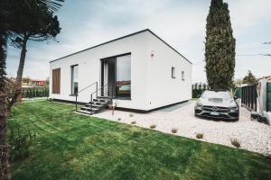 Biały dom z samochodem zaparkowanym na dziedzińcu w obiekcie Montelino Boutiquehouse w mieście Bardolino