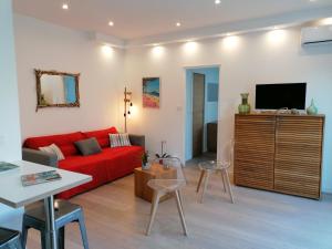 濱海聖西的住宿－Lou Farniente - Les Lecques - Fabuleux，客厅配有红色沙发和电视
