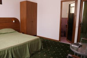 a bedroom with a bed and a door to a bathroom at Villa Beliv Guest House in Alushta