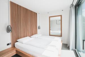 sypialnia z dwoma łóżkami i lustrem w obiekcie Montelino Boutiquehouse w mieście Bardolino