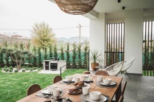 una sala da pranzo con tavolo e sedie e un giardino di Boutiquehouse Montelino a Bardolino