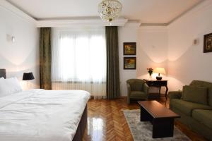 ein Schlafzimmer mit einem Bett, einem Sofa und einem Tisch in der Unterkunft Crown apartment - Your most comfortable stay in Belgrad