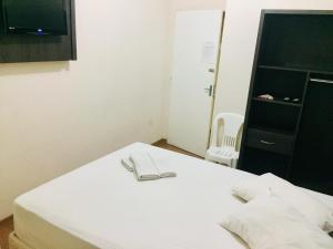 un letto bianco con un paio di occhiali sopra di Hotel GMatos Belo Horizonte - By UP Hotel a Belo Horizonte