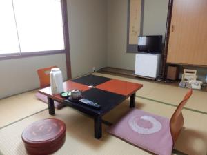a living room with a coffee table and a stool at Kikunoya Ryokan in Kanazawa