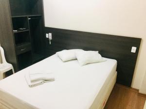 a white bed with two white towels on it at Hotel GMatos Belo Horizonte - Próximo a Rodoviária e Mercados Turísticos in Belo Horizonte