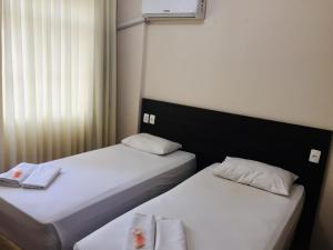 two beds sitting next to each other in a room at Hotel GMatos Belo Horizonte - Próximo a Rodoviária e Mercados Turísticos in Belo Horizonte