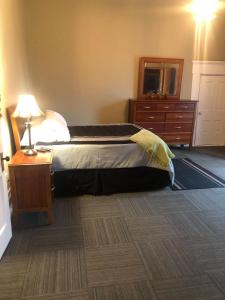 um quarto com uma cama com uma cómoda e um espelho em Suite 3 Eighteen em Shelbyville