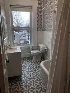 baño con bañera, aseo y ventana en Suite 3 Eighteen en Shelbyville