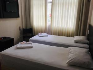 two beds in a hotel room with towels on them at Hotel GMatos Belo Horizonte - Próximo a Rodoviária e Mercados Turísticos in Belo Horizonte