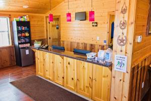 a bar in a wooden cabin with a refrigerator at Lone Star Lodge in Big Lake