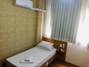a small bed in a room with a window at Hotel GMatos Belo Horizonte - Próximo a Rodoviária e Mercados Turísticos in Belo Horizonte