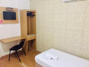 a room with a table and a chair and a desk at Hotel GMatos Belo Horizonte - Próximo a Rodoviária e Mercados Turísticos in Belo Horizonte