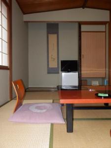 a living room with a table and a microwave at Kikunoya Ryokan in Kanazawa