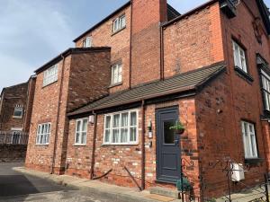 a brick building with a black door on a street at Be My Guest Liverpool - Ground Floor Apartment with Parking in Liverpool