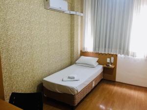 a small bedroom with a bed in a room at Hotel GMatos Belo Horizonte - Próximo a Rodoviária e Mercados Turísticos in Belo Horizonte