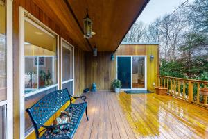 a porch with a bench on a wooden deck at East Hampton Retreat in East Hampton