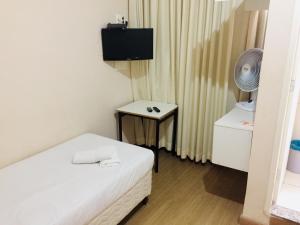 a room with a bed and a table with a fan at Hotel GMatos Belo Horizonte - Próximo a Rodoviária e Mercados Turísticos in Belo Horizonte