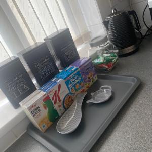 a tray with two boxes of cereal and a pair of utensils at Be My Guest Liverpool - Ground Floor Apartment with Parking in Liverpool