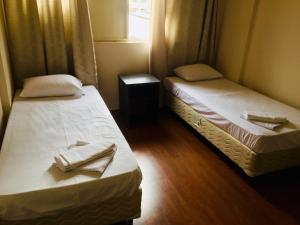 two beds in a small room with a window at Hotel GMatos Belo Horizonte - Próximo a Rodoviária e Mercados Turísticos in Belo Horizonte