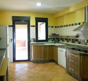 a kitchen with yellow walls and wooden cabinets at Miradores - Apartamentos El Cabo in Las Majadas