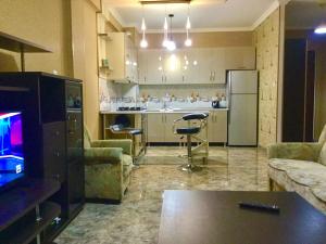 ein Wohnzimmer mit einem TV und einer Küche in der Unterkunft Welcome Genatsvale in Tbilisi City