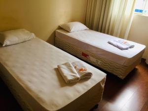 two beds sitting next to each other in a room at Hotel GMatos Belo Horizonte - Próximo a Rodoviária e Mercados Turísticos in Belo Horizonte