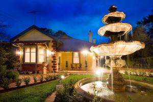 a fountain in front of a house at night at Mountain Whispers Varenna Luxury in Leura
