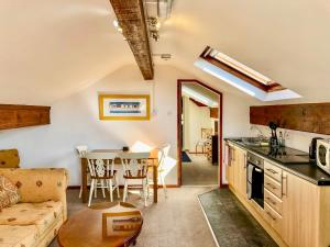 a kitchen and living room with a couch and a table at Heather in Ruthin