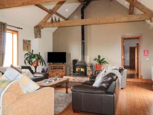 un soggiorno con mobili in pelle e camino di Longstone Cottage a Ugthorpe