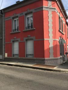 a red building on the side of a street at Couleur Framboise in Longwy