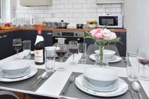 uma mesa com copos de vinho e um vaso de flores em Orion House - sleeps 6, driveway, garden em Crewe