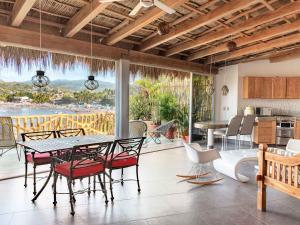 a dining room with a table and chairs and a kitchen at Villa Amor in Sayulita