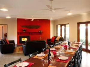 a dining room with a long table and a fireplace at Burncroft Guesthouse in Lovedale