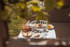 a white table with plates of food on it at Herdade da Rocha - Boutique Lodge in Crato