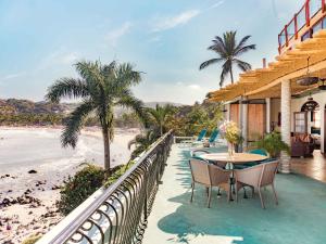 a balcony with a table and chairs and the beach at Villa Amor in Sayulita