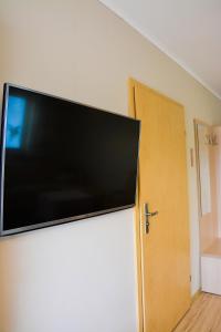 einen Flachbild-TV an einer Wand neben einer Tür in der Unterkunft Restauracja 32 Motel in Gryfice